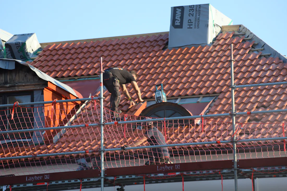 Roofing crew member working on a residential roof